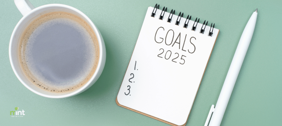 Photo of cup of coffee, a white notepad with the words "Goals 2025" and "1. 2. 3." in a list with a pen