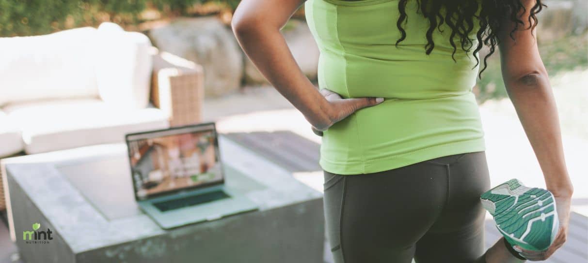 Woman stretching at home before an online workout to support healthy weight loss in Mooresville NC