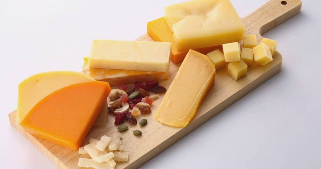 Cheese board with dried fruit and nuts, foods higher in mold and yeast that can trigger gut symptoms after mold exposure.