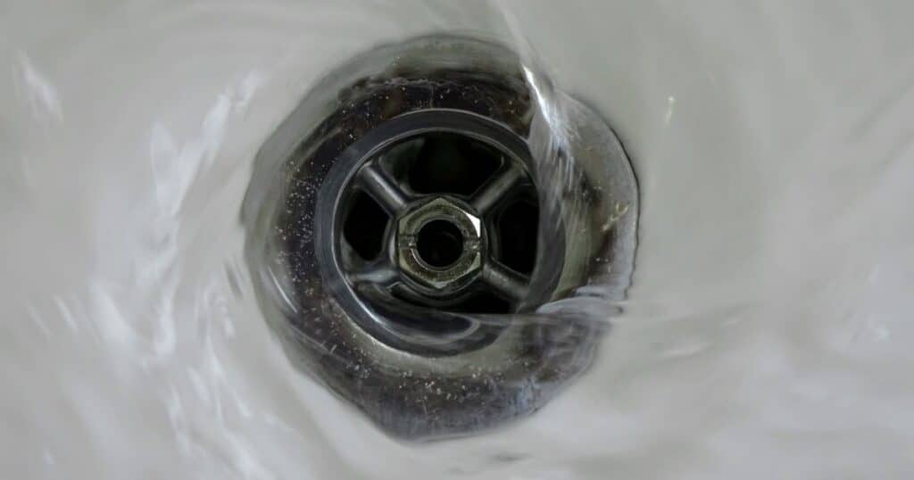 Water swirling down a drain, symbolizing the need to clear the liver, gallbladder, and kidneys before mold detox can work.