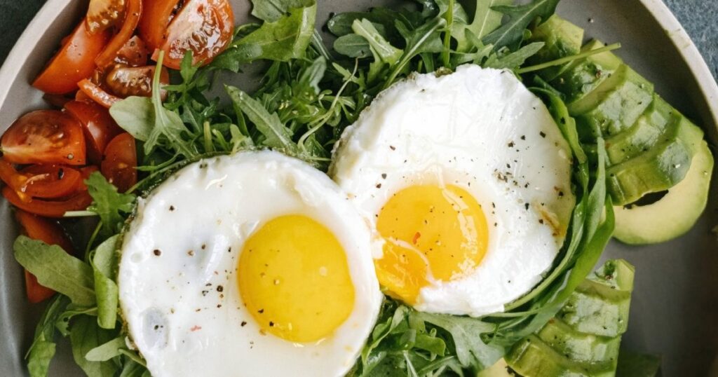 Balanced protein-rich breakfast plate with eggs, greens, and avocado to support circadian rhythm nutrition